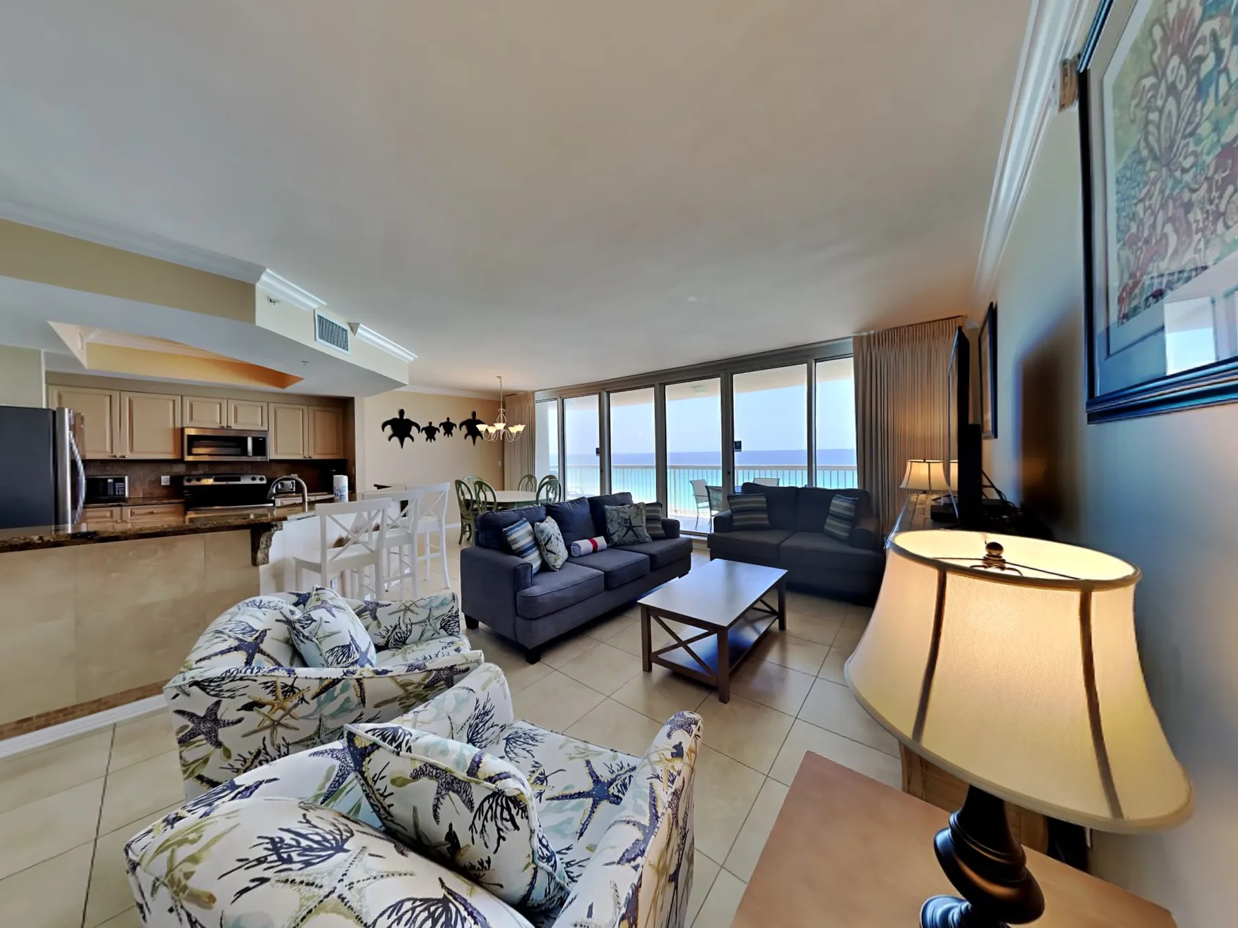 A living room with seating, a coffee table, and large windows overlooking the water.