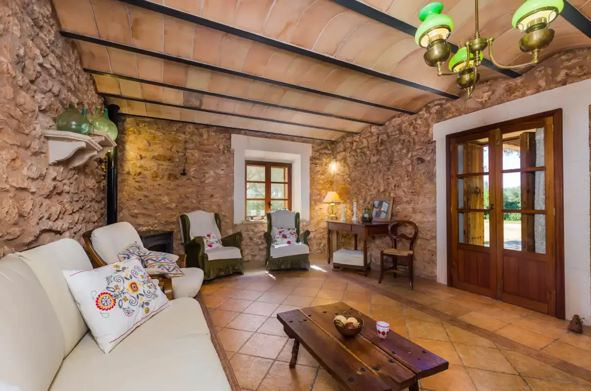 A stone-walled living room with seating and a wooden coffee table.