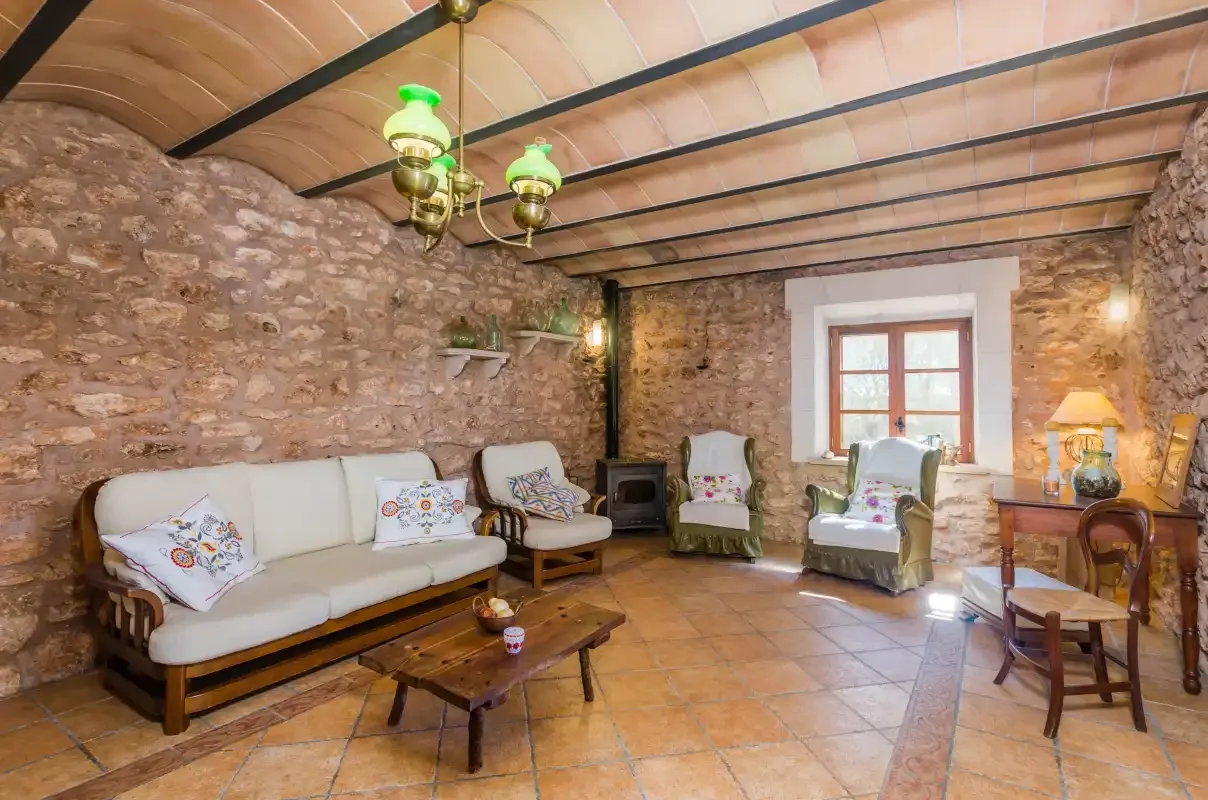 A rustic living room with seating, a coffee table, and a window.