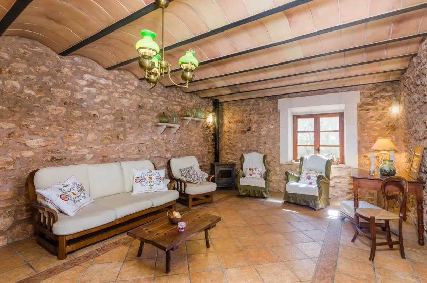 A rustic living room with seating, a low table, and a window.