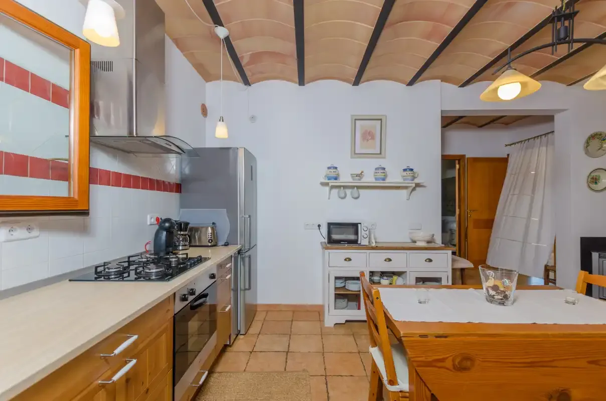 A kitchen and dining area with wooden cabinets and a table.
