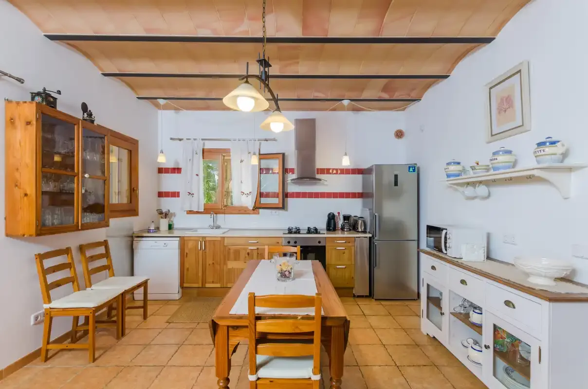 A kitchen and dining area with wooden cabinets and a central table.