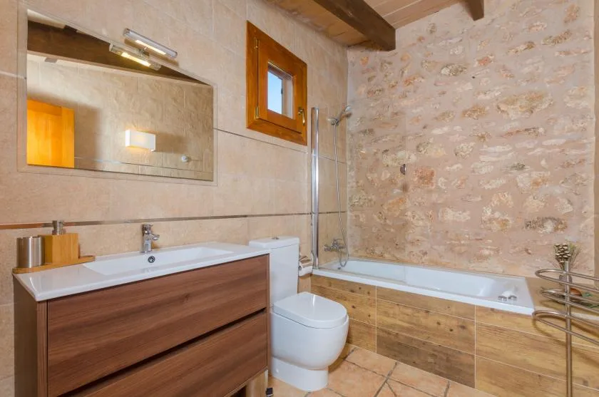 A bathroom with a bathtub, vanity, and toilet.
