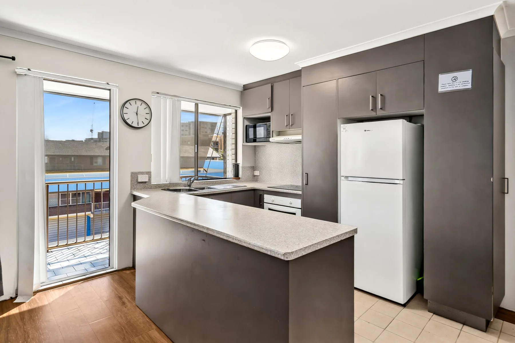 Una cocina luminosa con una barra y un refrigerador.