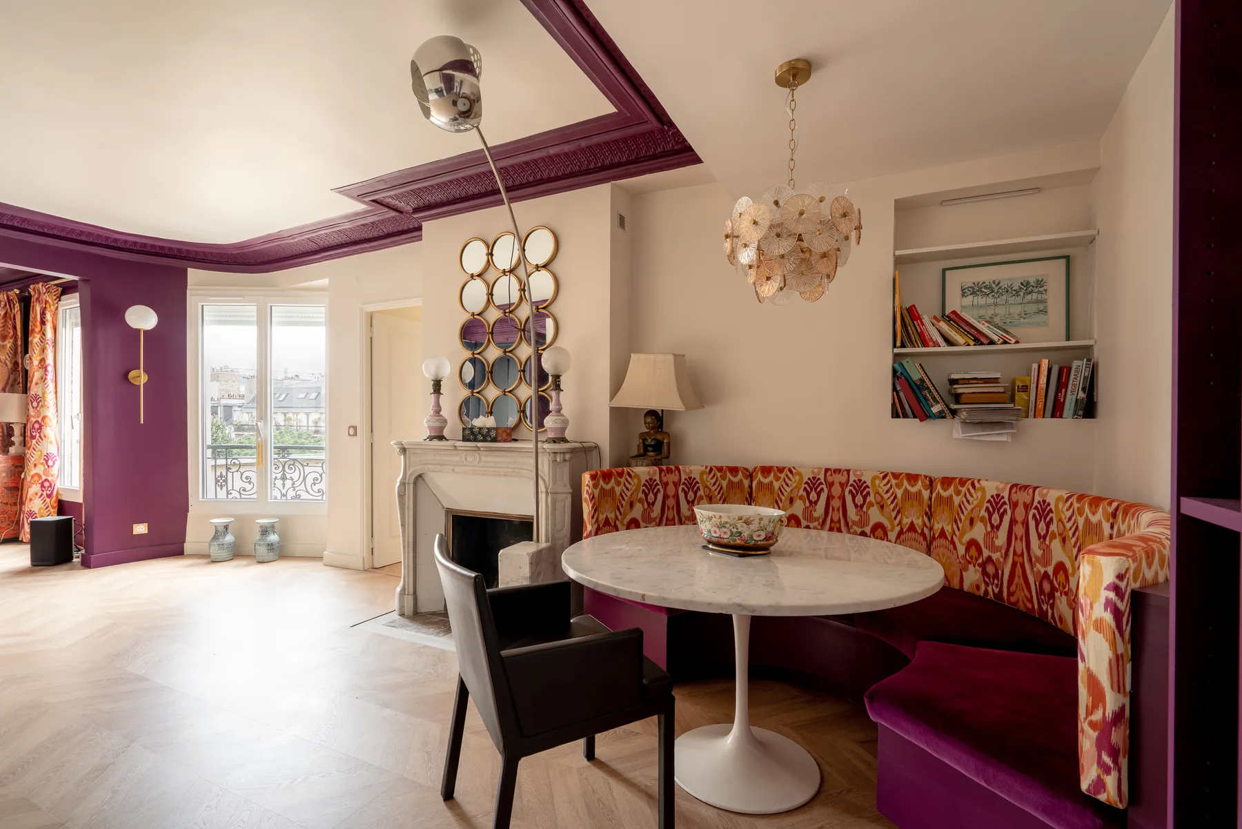 Una sala colorida con asientos estampados alrededor de una mesa redonda.