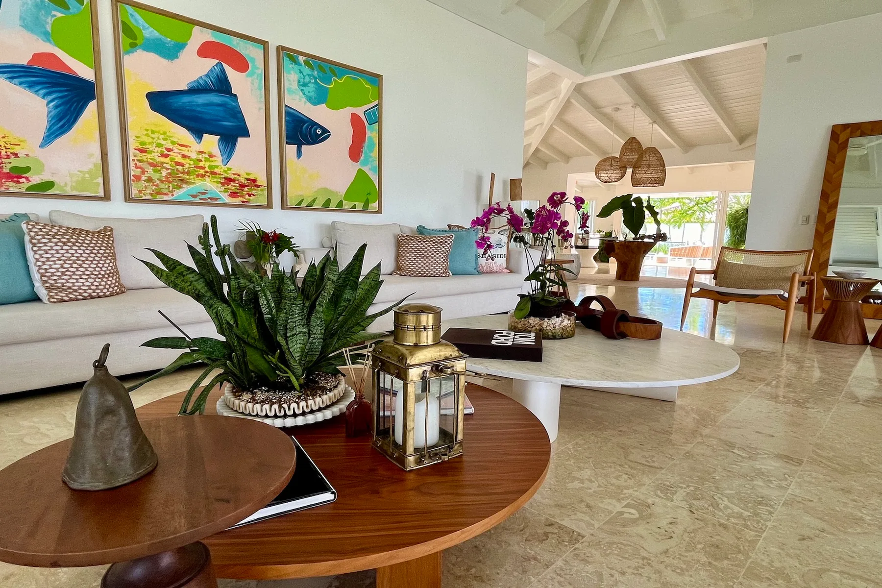 Una sala luminosa cuenta con asientos, obras coloridas y una mesa baja.