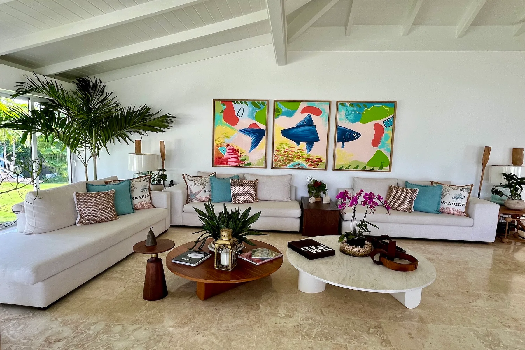 Una sala luminosa tiene asientos claros, mesas bajas y obras de arte coloridas.