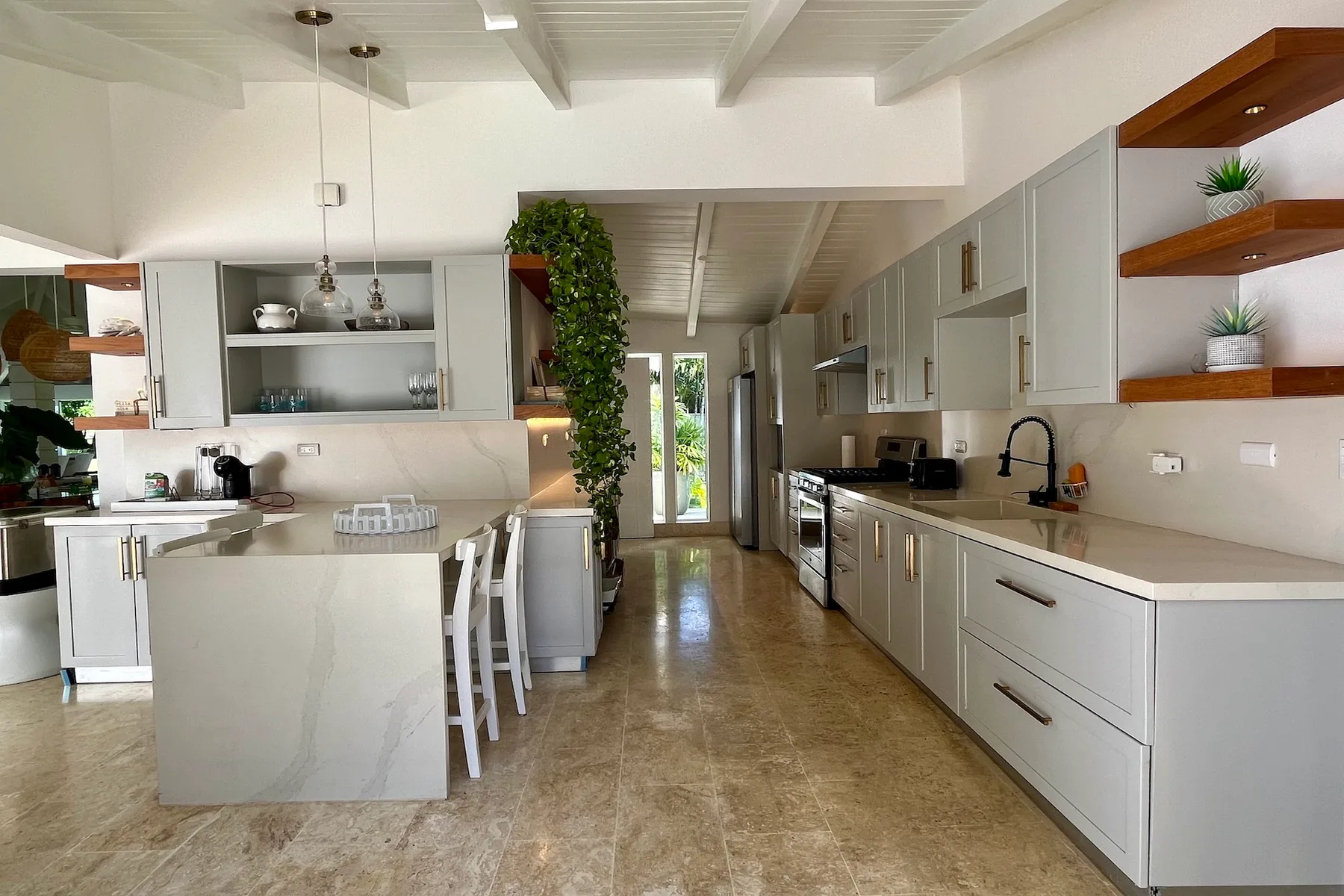 Una cocina luminosa con zona de comedor, una encimera larga y una mesa.