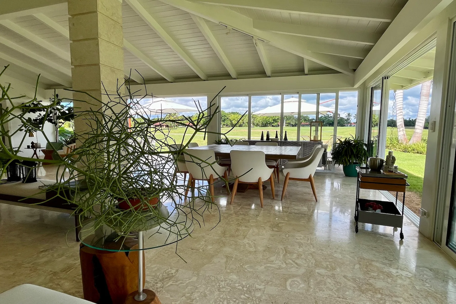 Un comedor luminoso con una mesa larga y amplias ventanas con vistas a un paisaje verde.