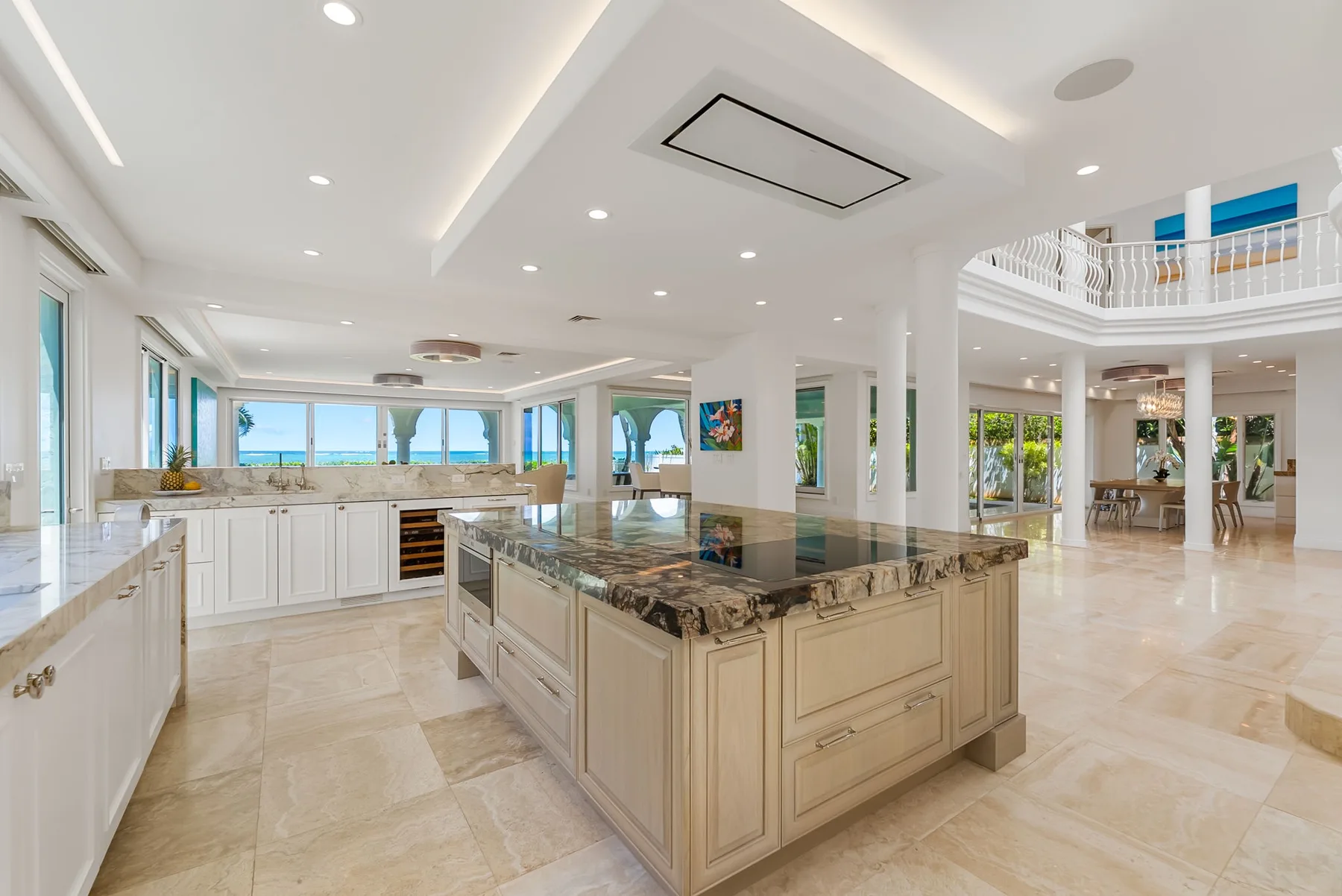 Una cocina amplia y luminosa con una gran isla central y ventanales.