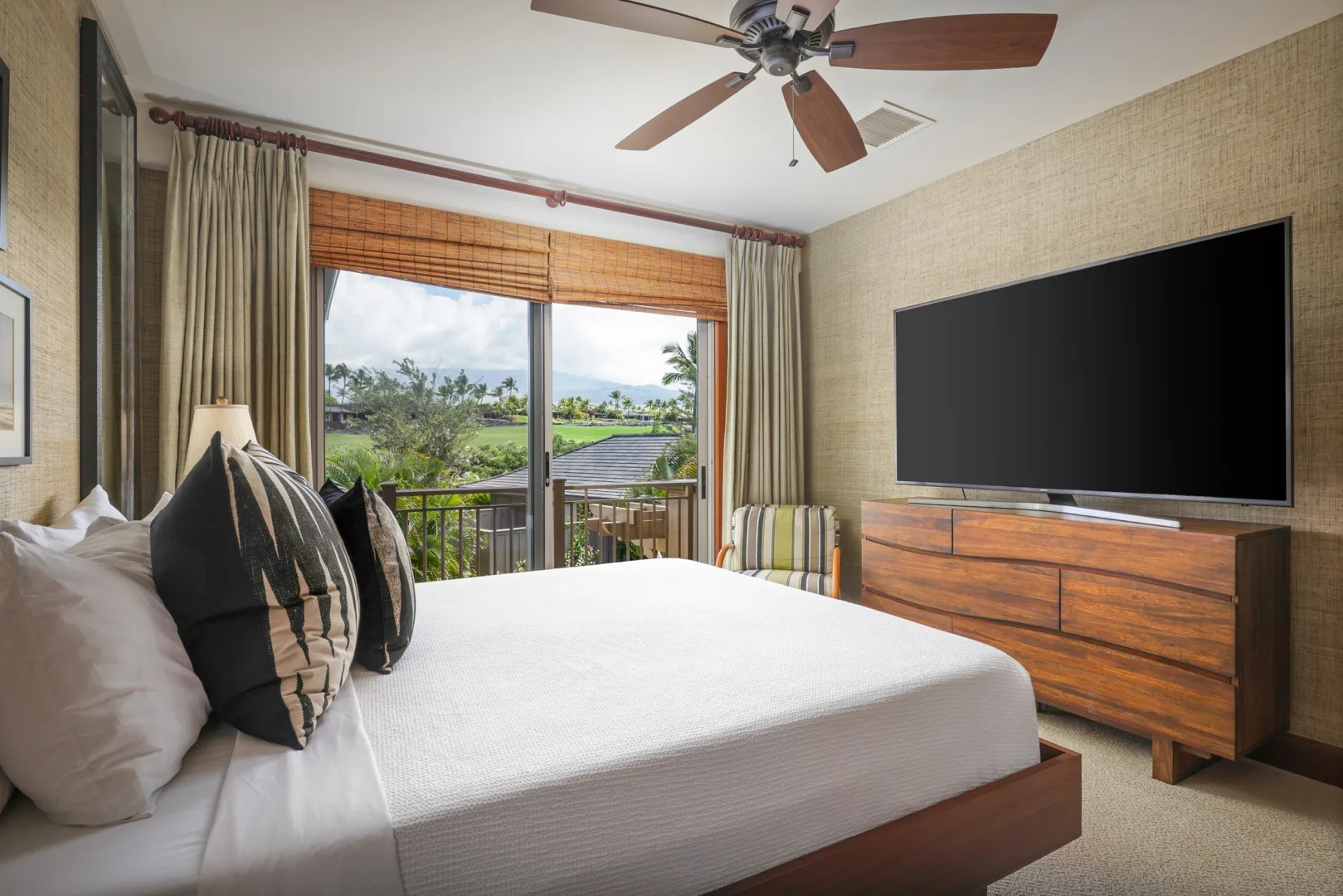 Un dormitorio con una cama, un televisor y una vista por la ventana.
