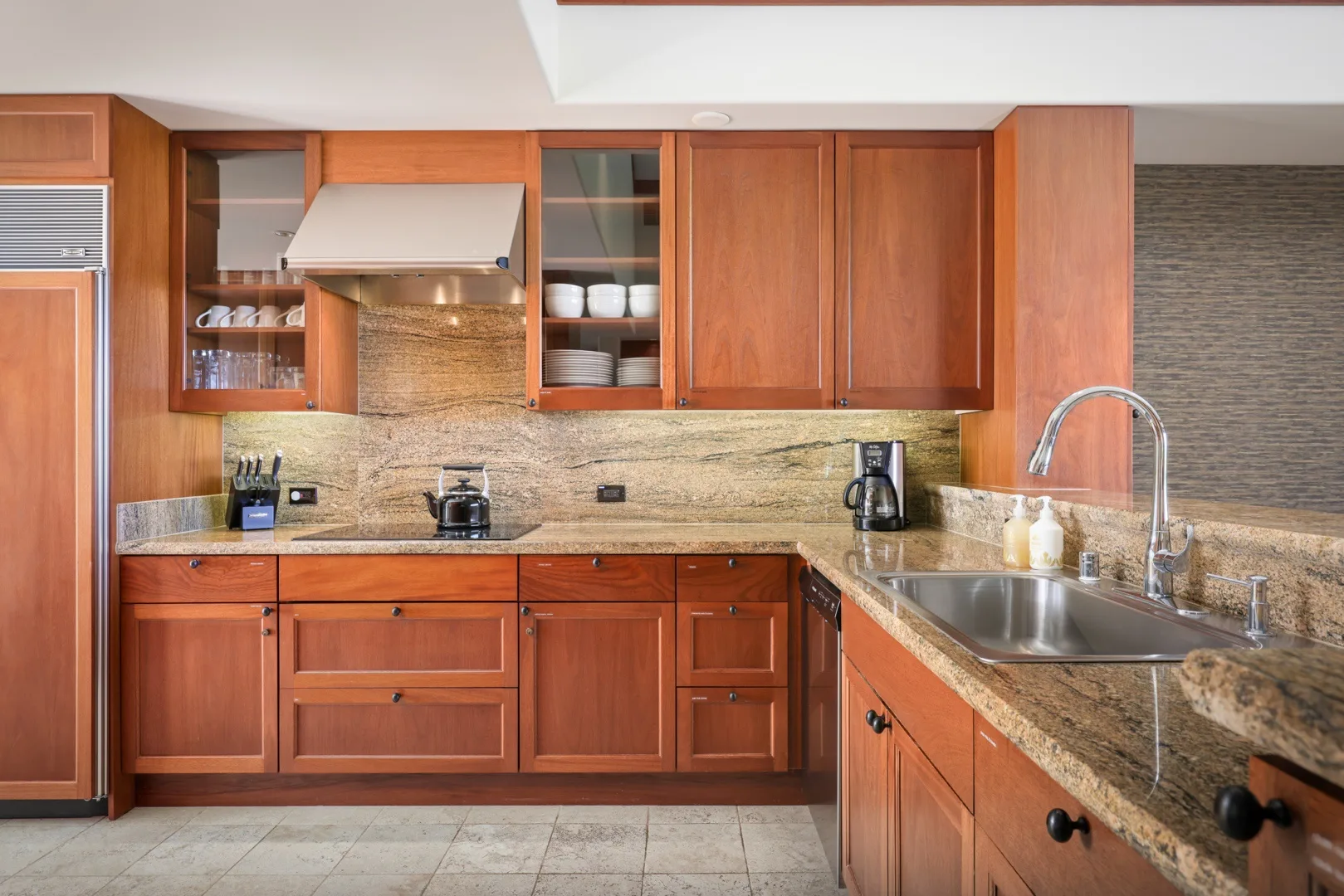 Una cocina con gabinetes de madera y una encimera de piedra.