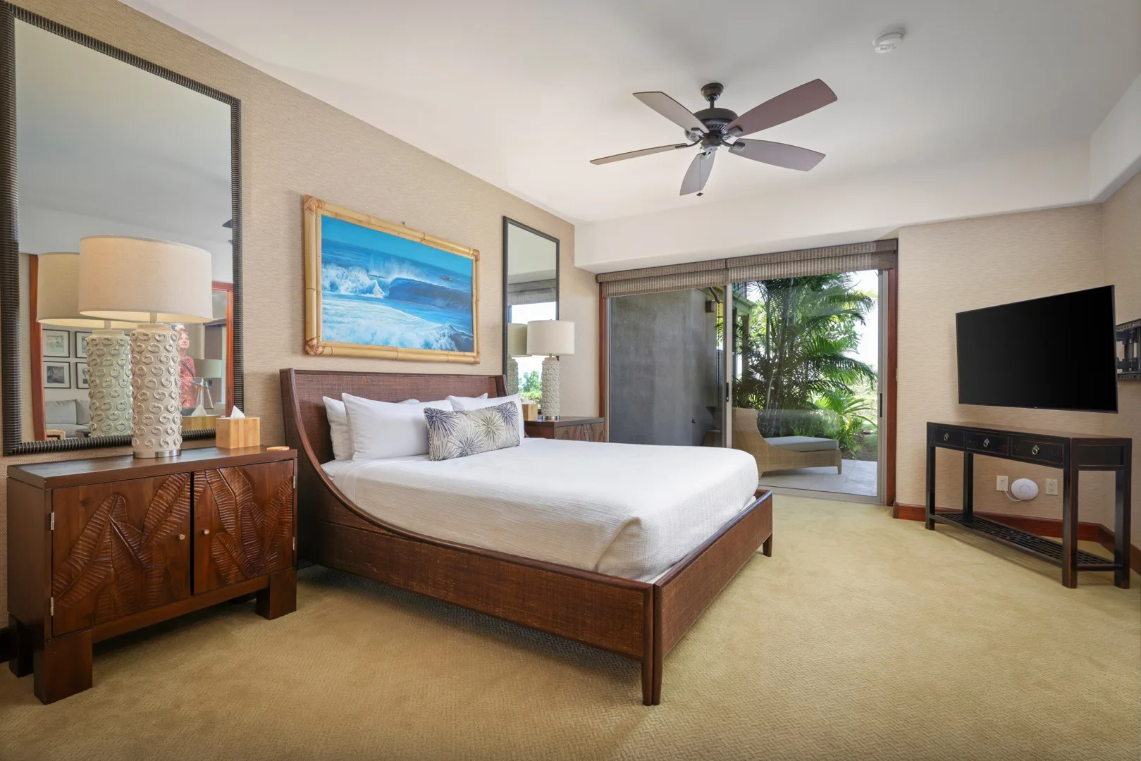 Un dormitorio con una cama grande, muebles junto a la cama y un televisor.