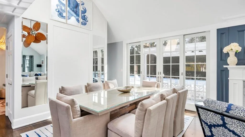 A bright dining area with a glass table and large windows.