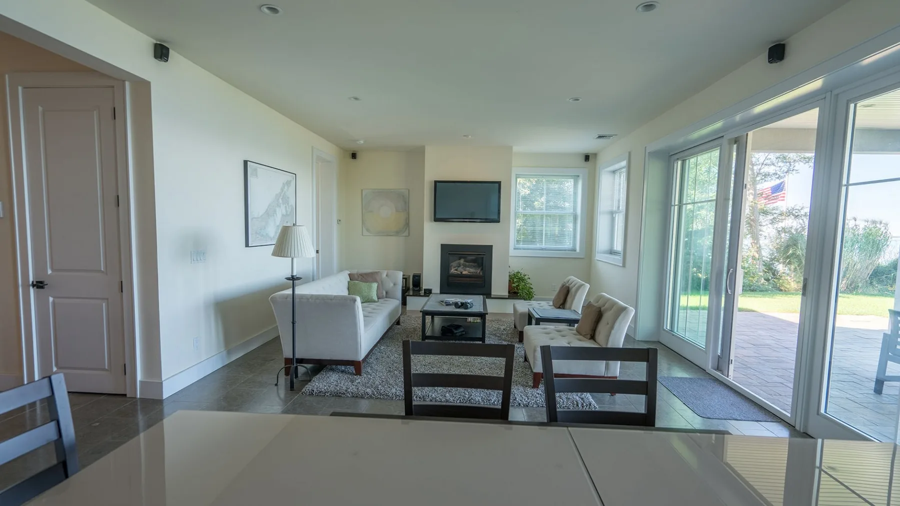 A bright living room with seating arranged around a coffee table and large windows.
