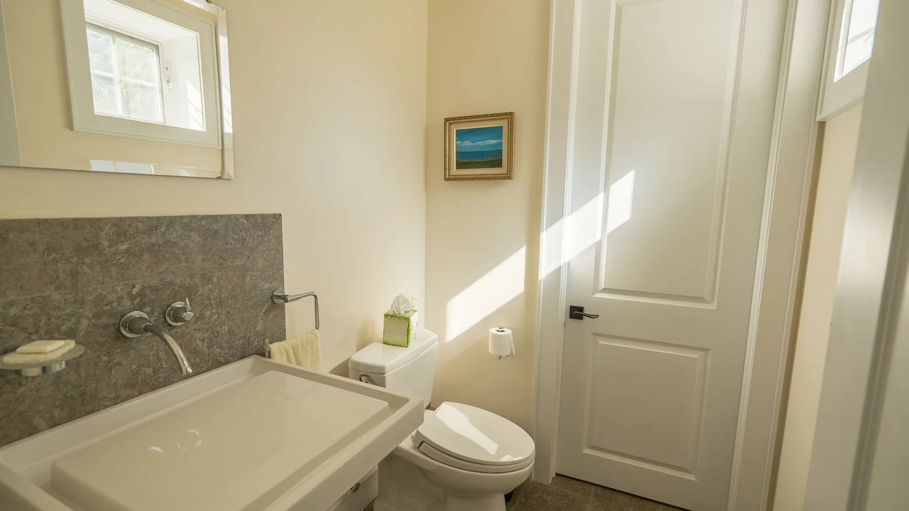 A bathroom with a sink, toilet, and closed door.