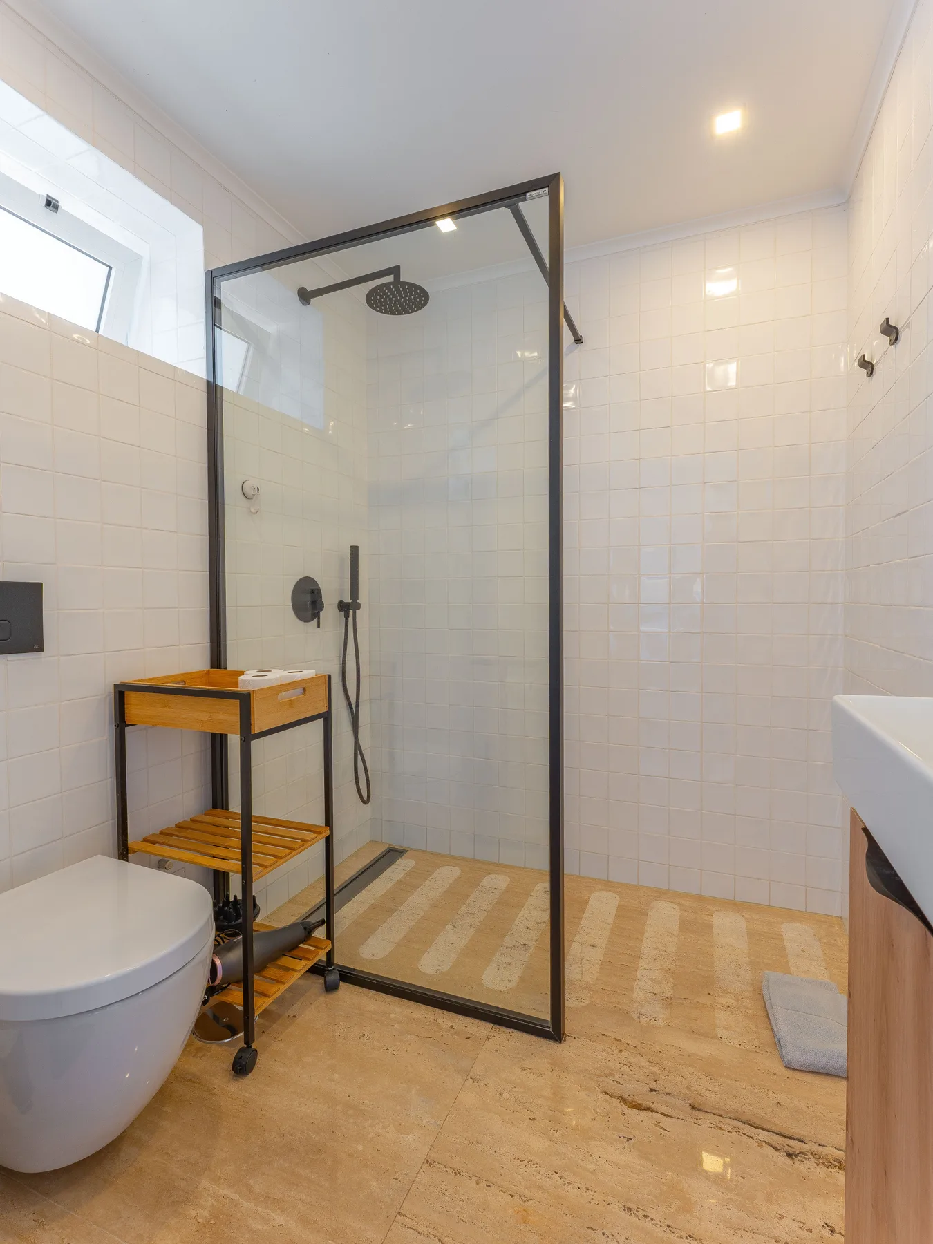 A tiled bathroom with a glass shower and a toilet.