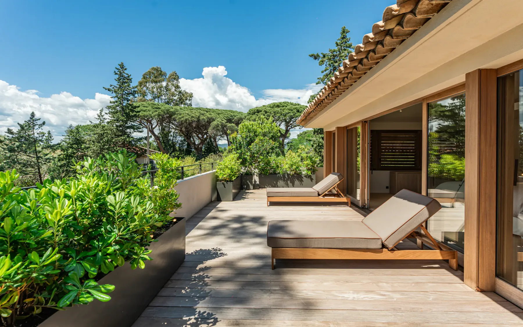 Una amplia terraza con asientos de descanso junto a una vegetación exuberante.