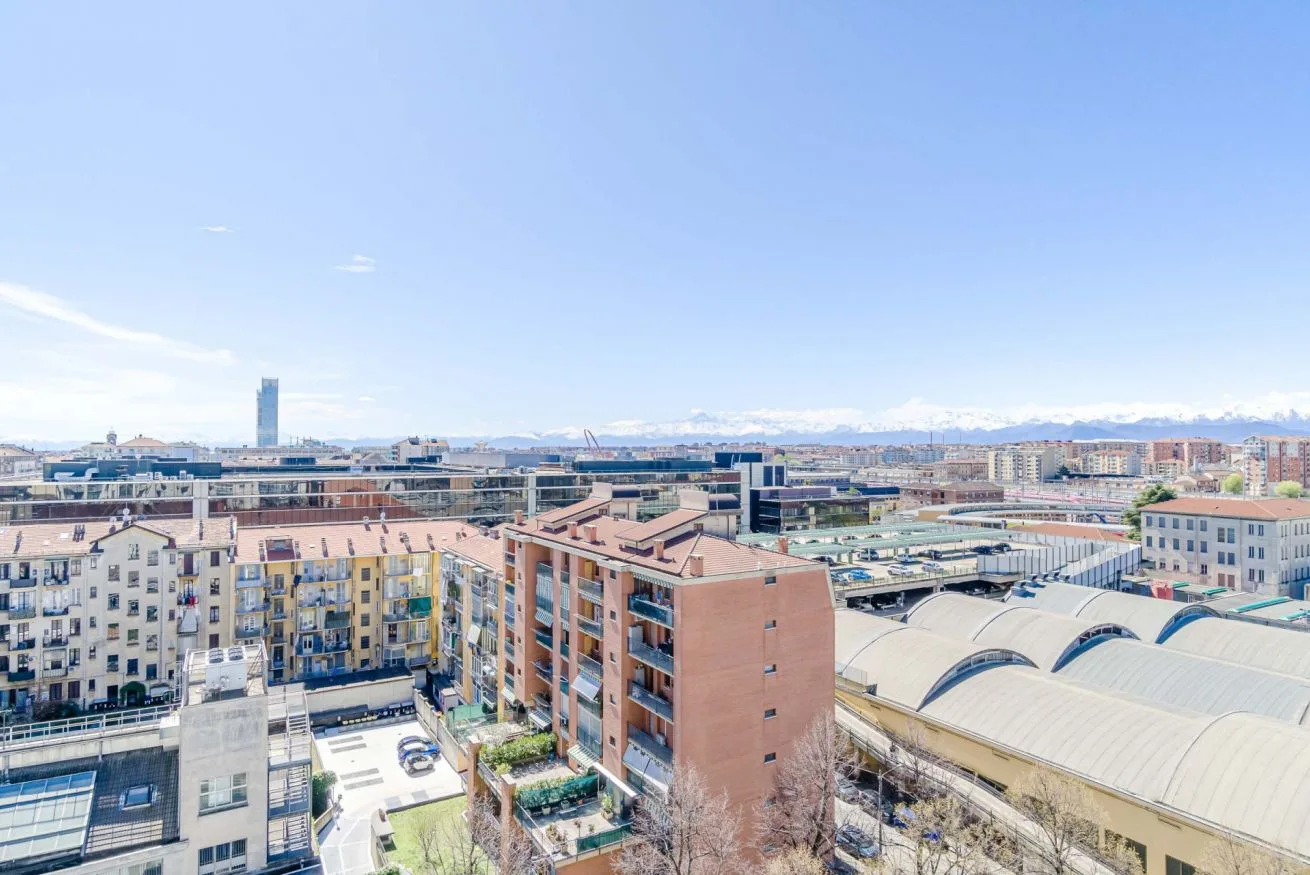 Una vista urbana con edificios de apartamentos y tejados curvos bajo un cielo despejado.