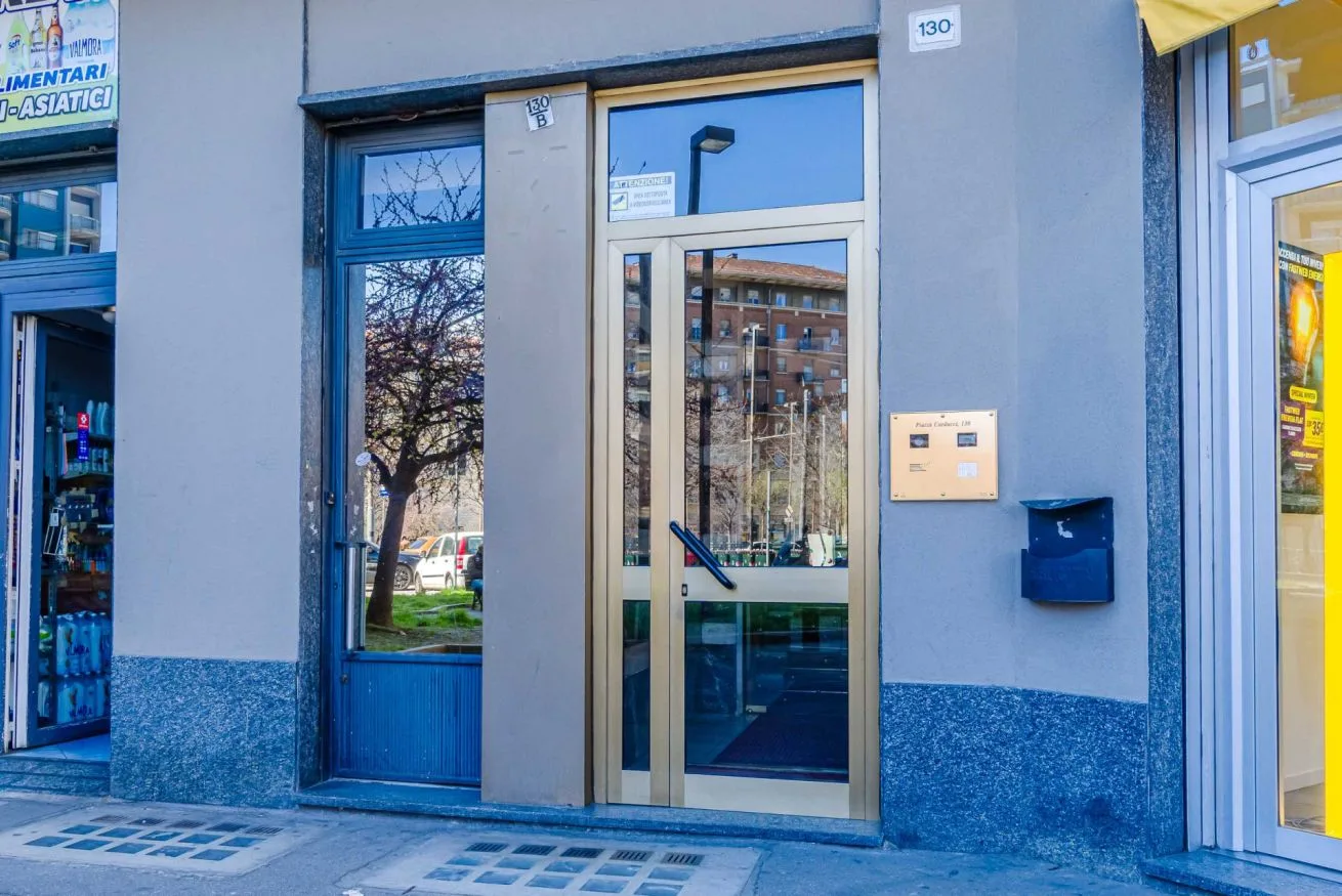 Una entrada a nivel de calle con una puerta de vidrio y molduras azules.