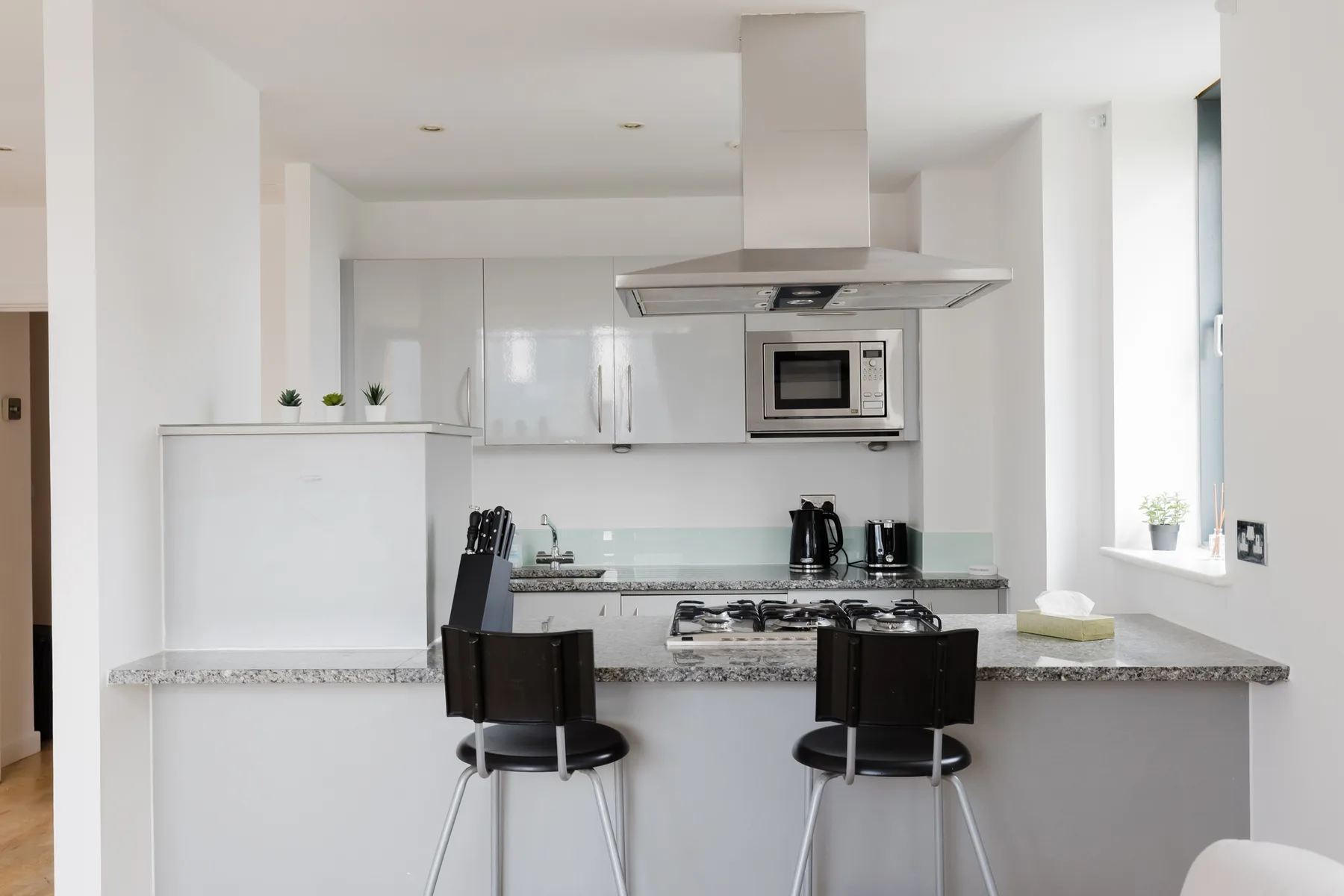 Una cocina luminosa con una barra y electrodomésticos modernos.