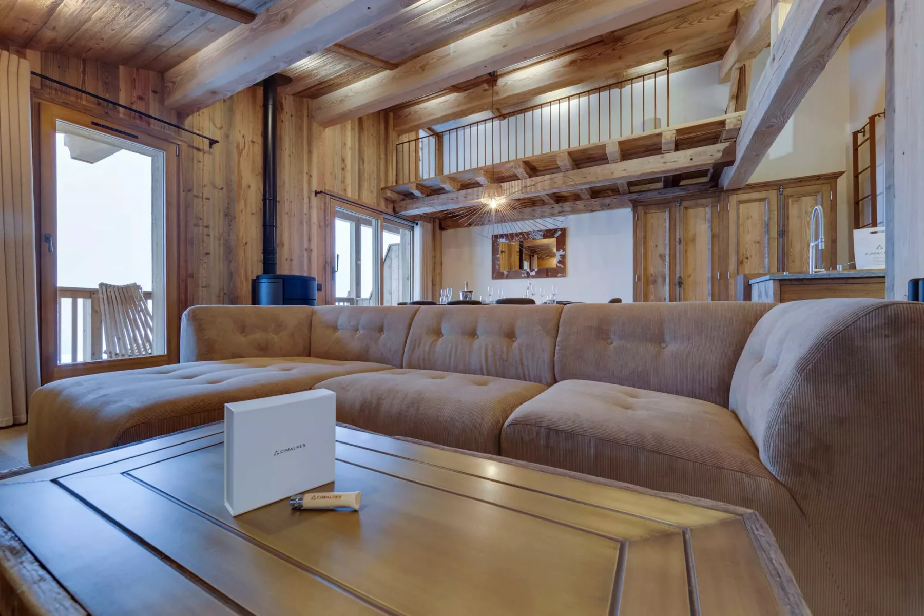 A wood-paneled living room with a large sectional sofa and coffee table.