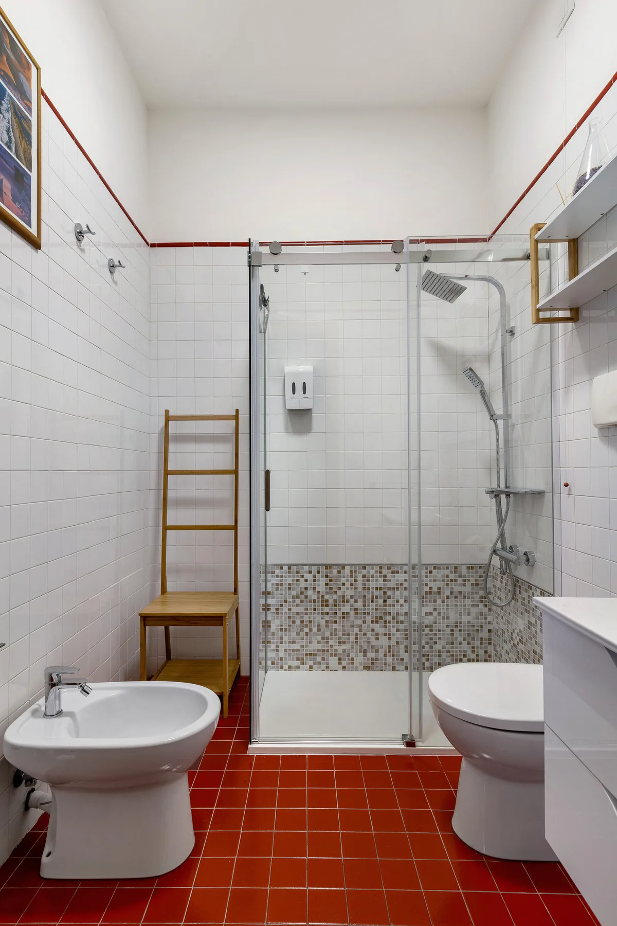 Un baño con azulejos, ducha de vidrio, inodoro y lavabo.