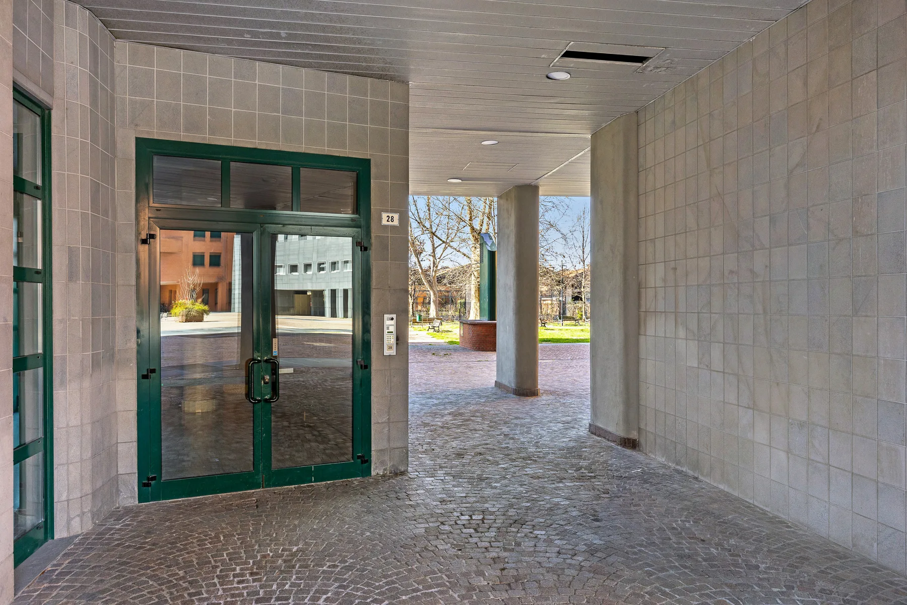Una entrada cubierta se abre a un paso exterior.