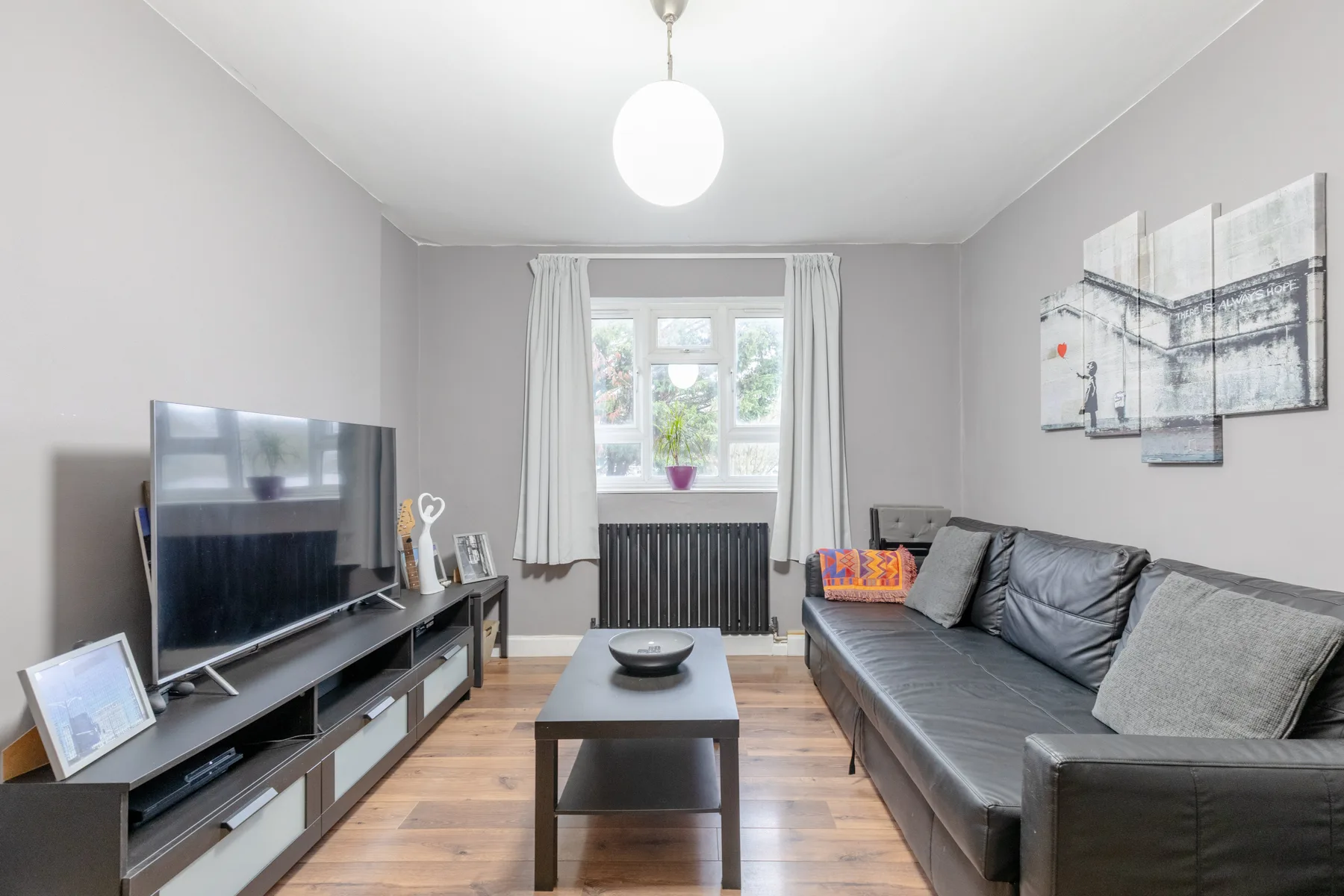 A living room with a gray sofa, television, and coffee table.