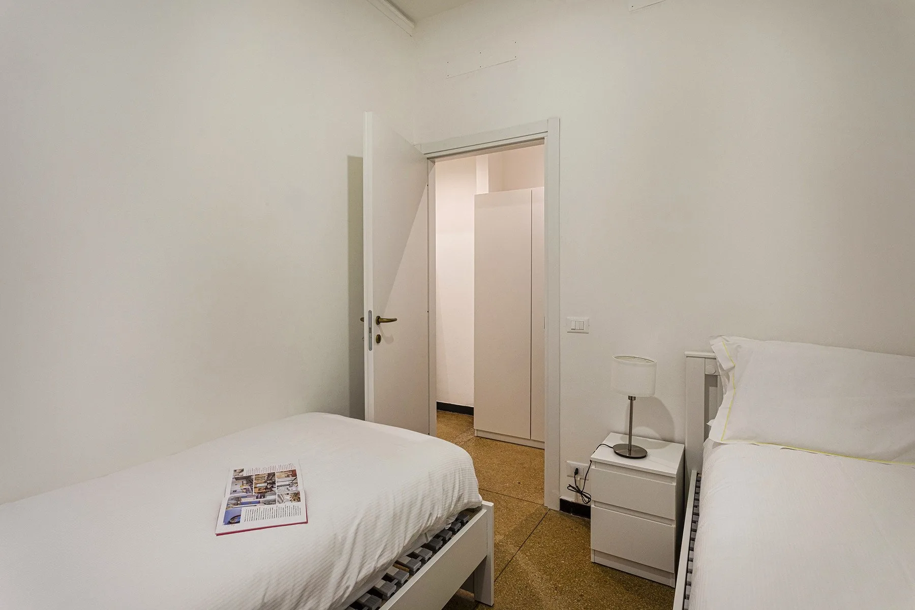 Un dormitorio con dos camas y una mesita de noche.