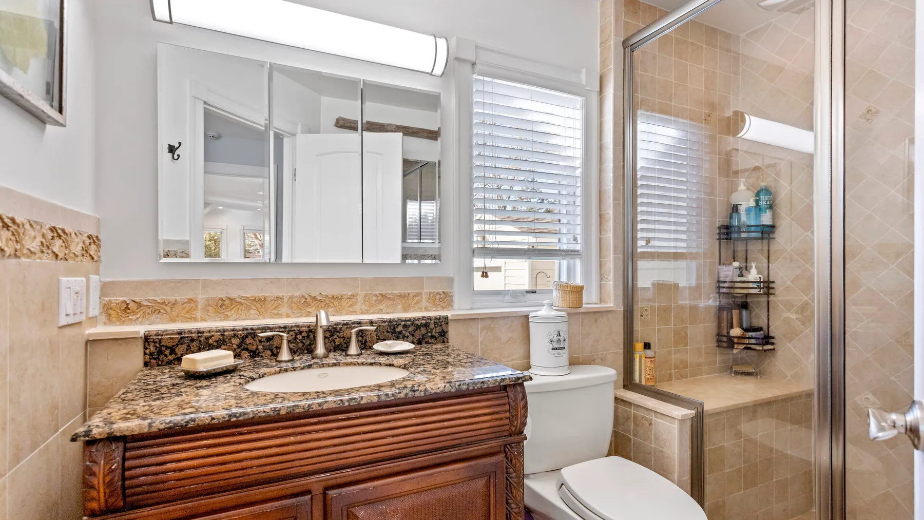 Un lavabo de baño está junto a una ducha de vidrio y un inodoro.