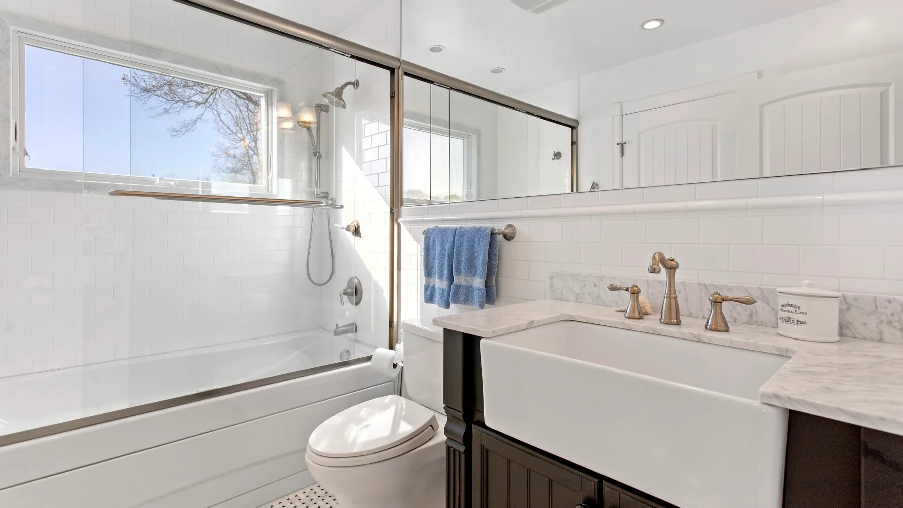 Un baño luminoso con bañera, inodoro y lavabo amplio.