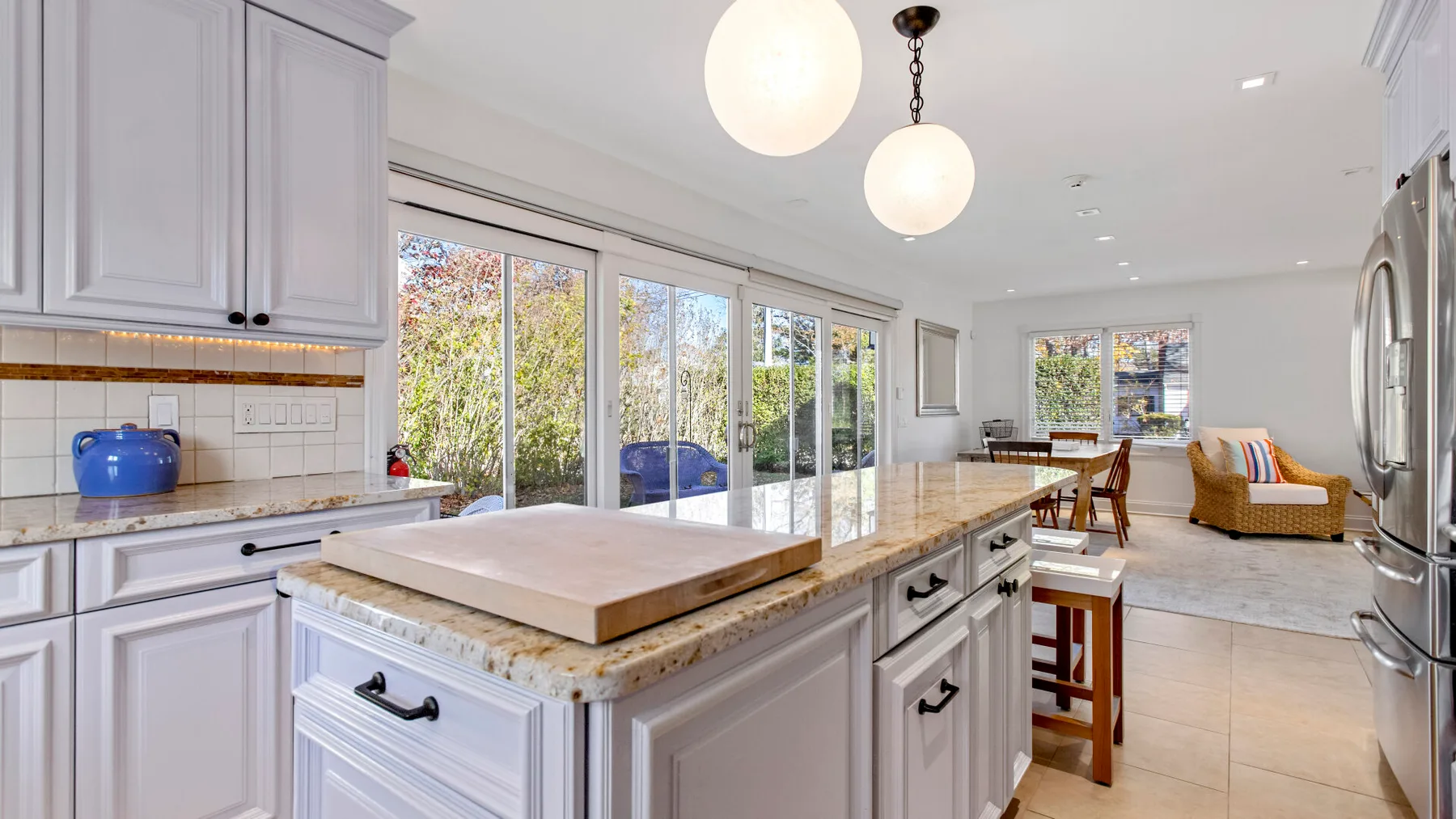 Una cocina luminosa con una isla central y grandes ventanas con vistas a la vegetación.