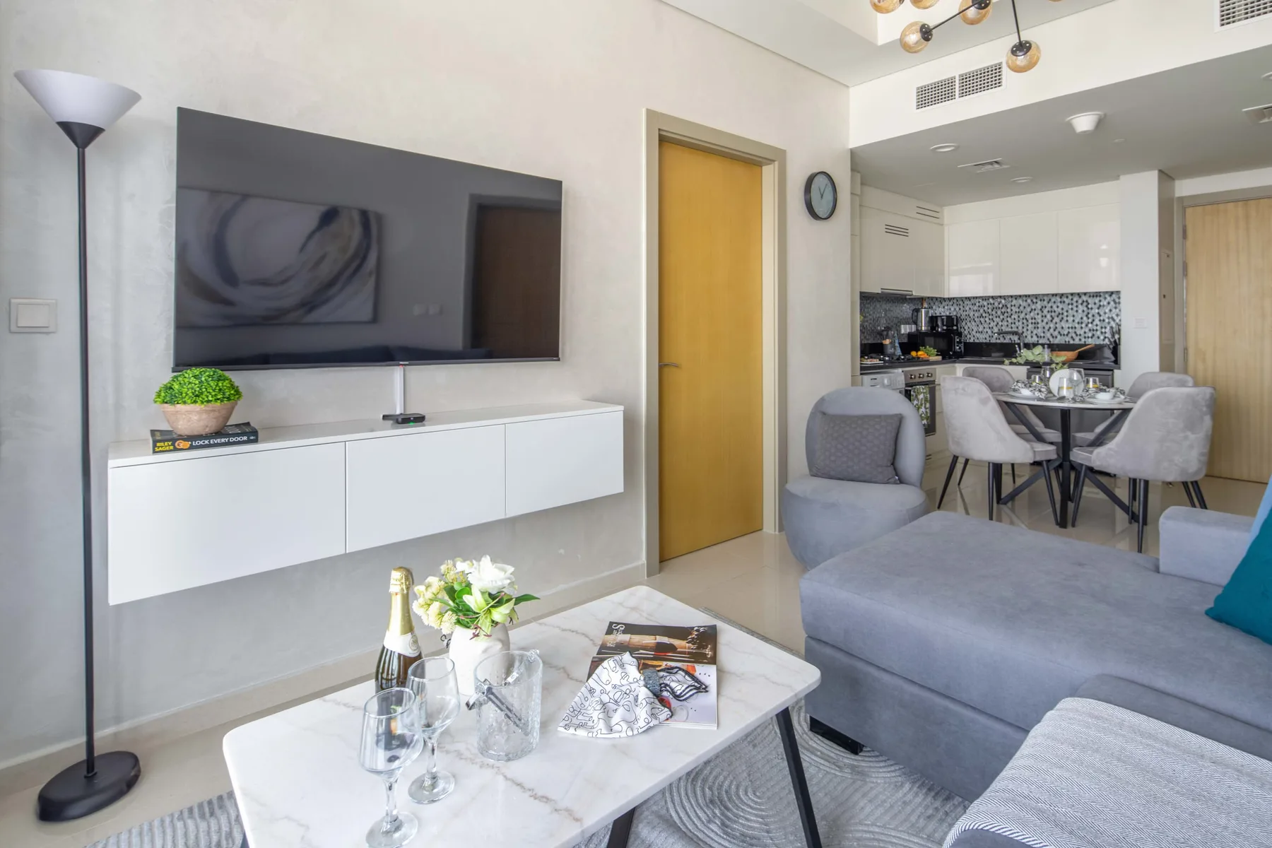 A bright living room opens onto a dining area and modern kitchen.