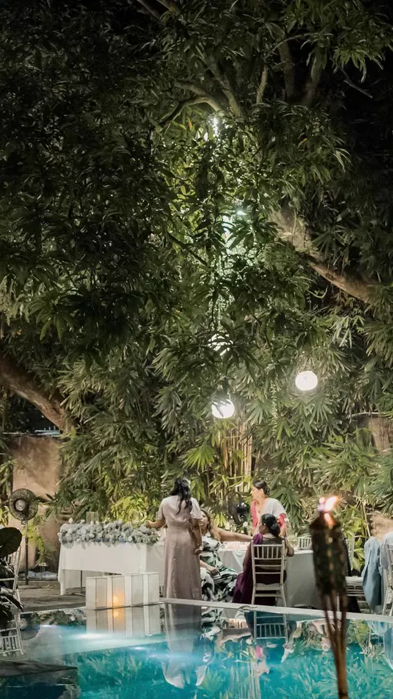Recepción en el jardín junto a la piscina iluminada.