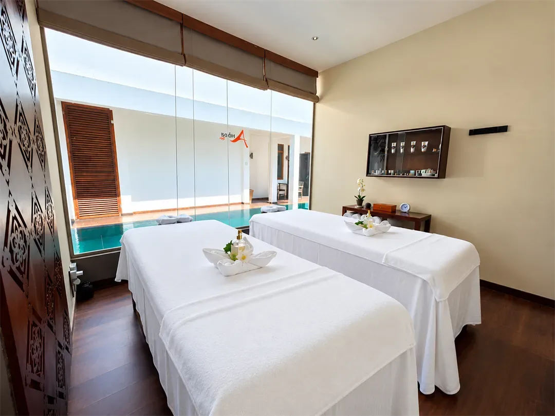 Sala de tratamientos para dos personas en The Court Spa, con una pequeña piscina al fondo.