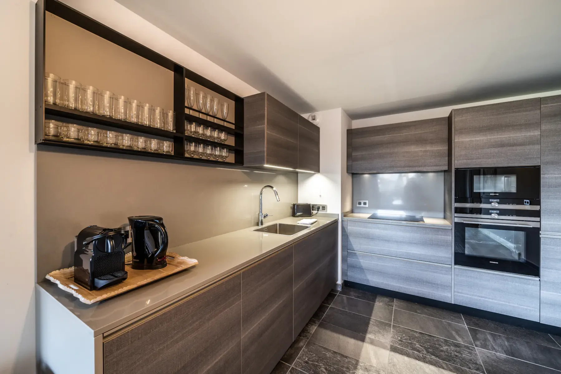 Una cocina contemporánea con armarios oscuros, encimera y electrodomésticos integrados.