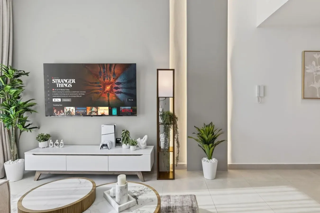 Sala de estar con un televisor montado en la pared y asientos bajos.