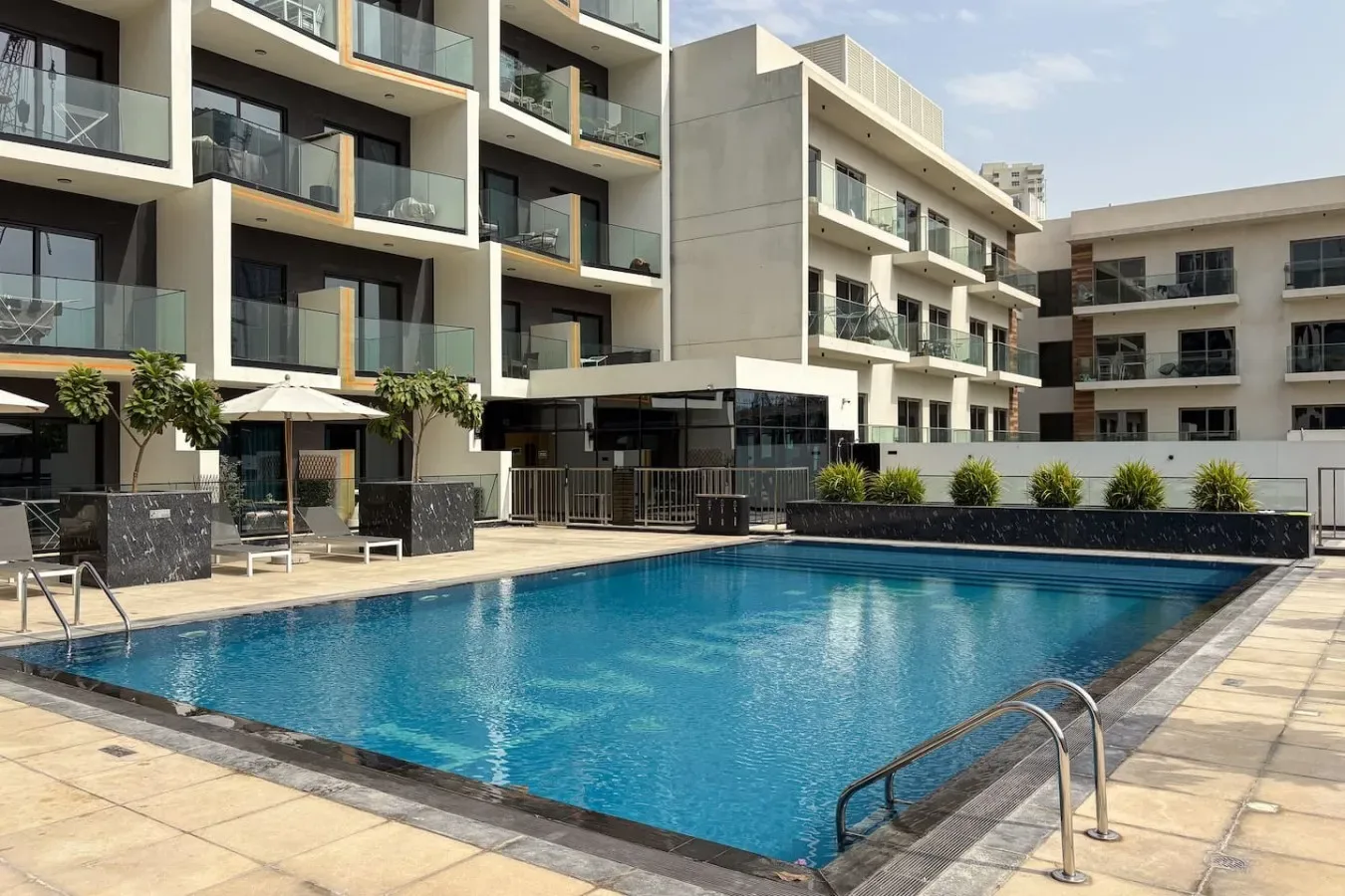 Una piscina al aire libre está junto a modernos edificios de apartamentos.