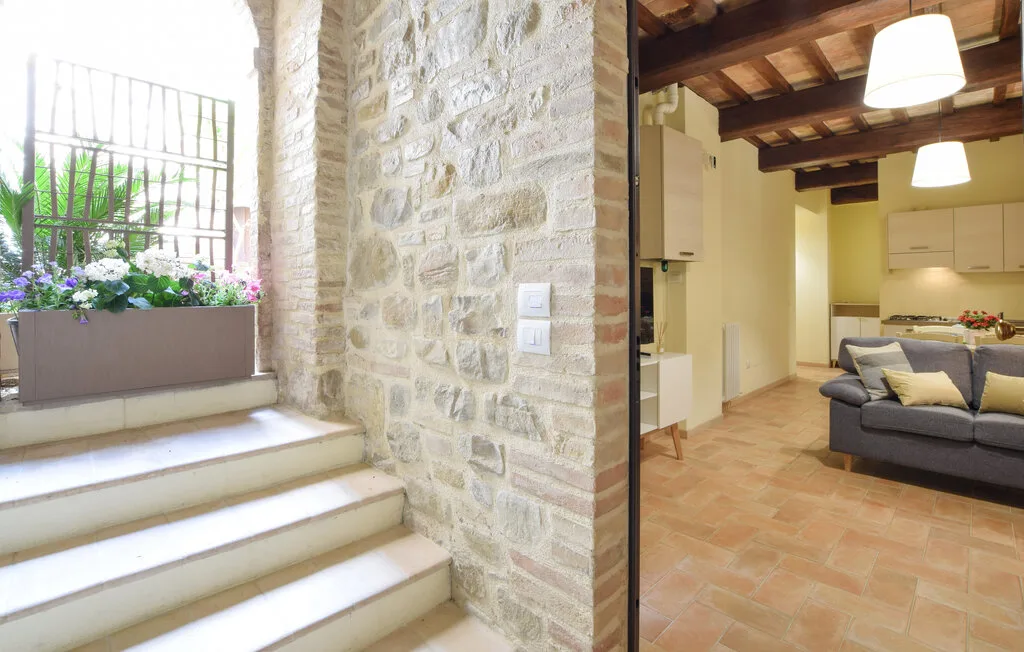 A stone stairway beside a living area with seating and a kitchen.