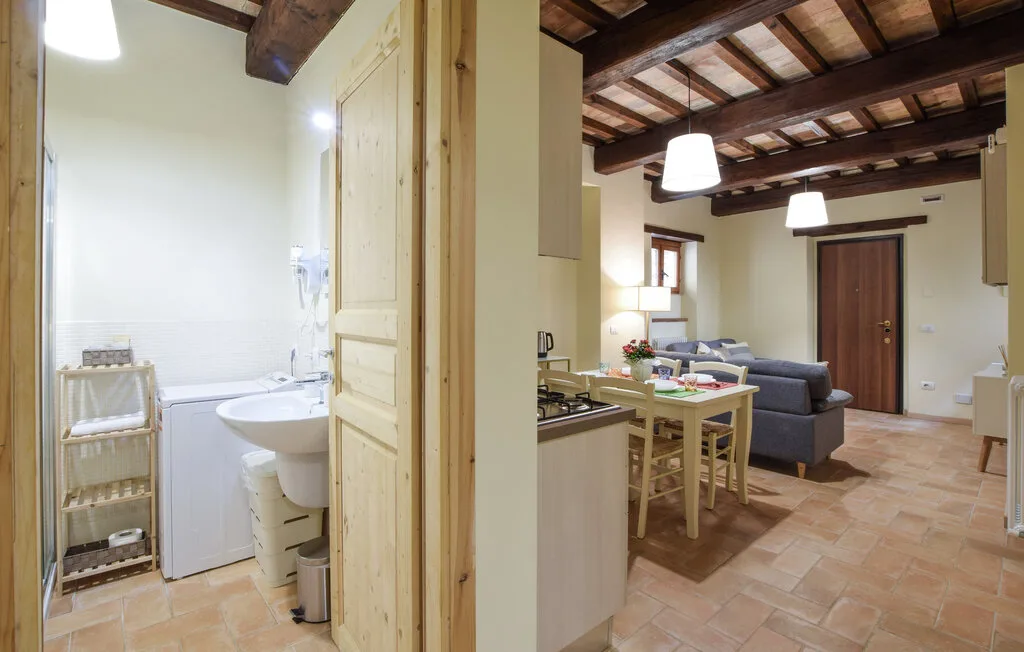 An open-plan kitchen, dining, and living area with an adjoining bathroom.