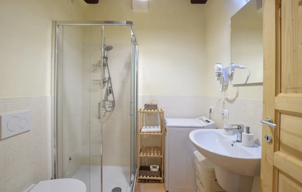 A bathroom with a glass shower and a sink.