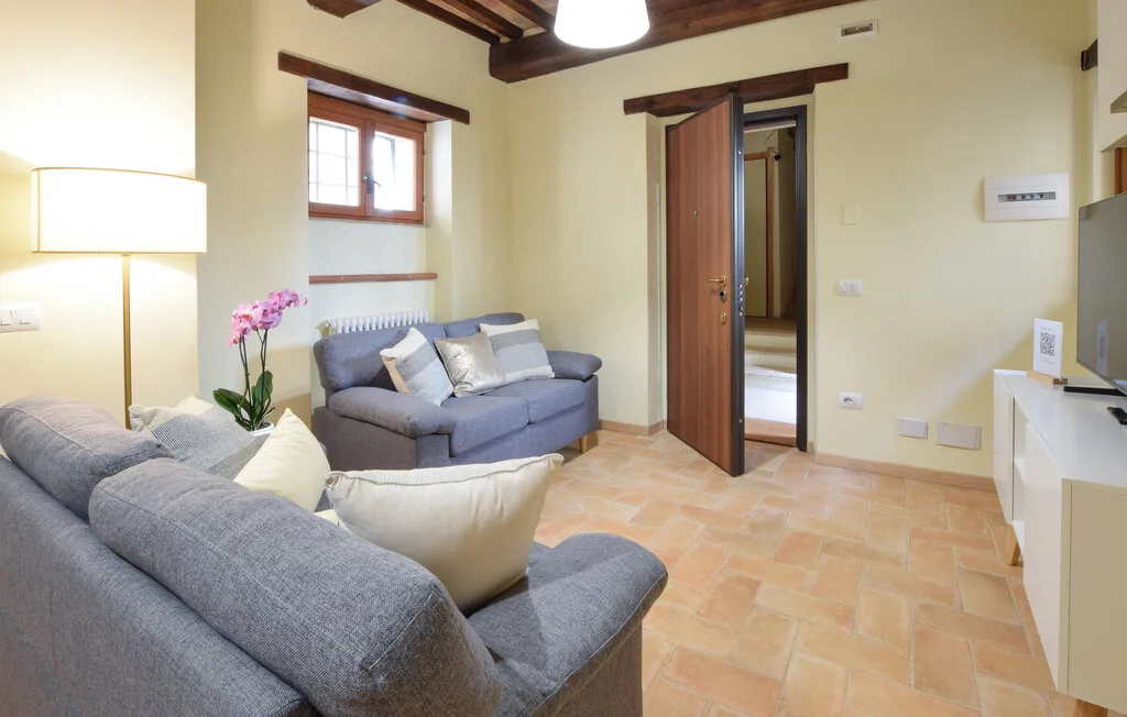 A living room with gray seating, a window, and a doorway.