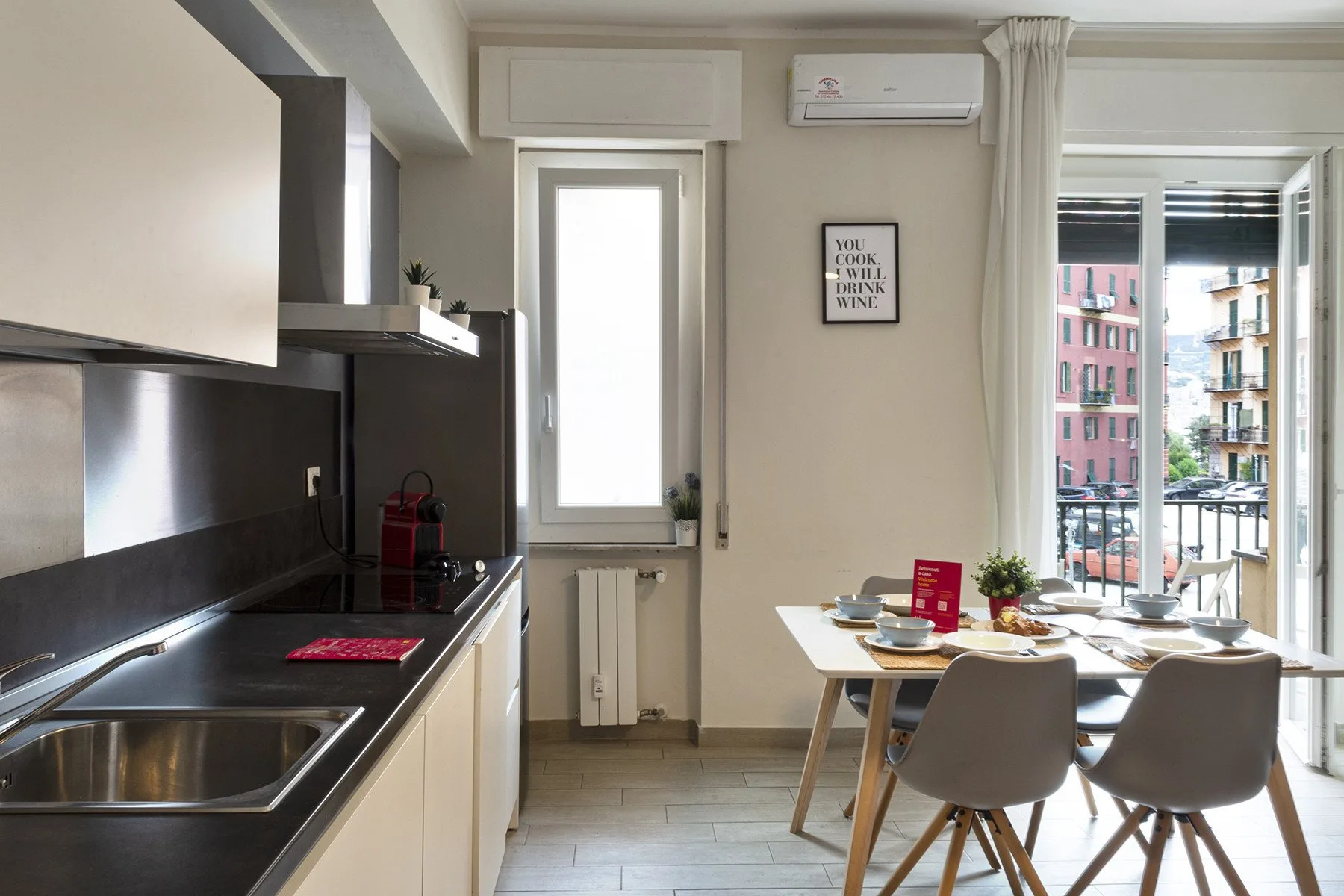 A bright kitchen and dining area with a table beside the balcony doors.