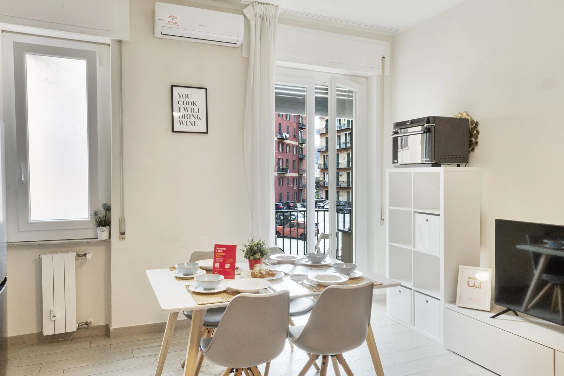 A bright dining area with a set table beside tall windows.