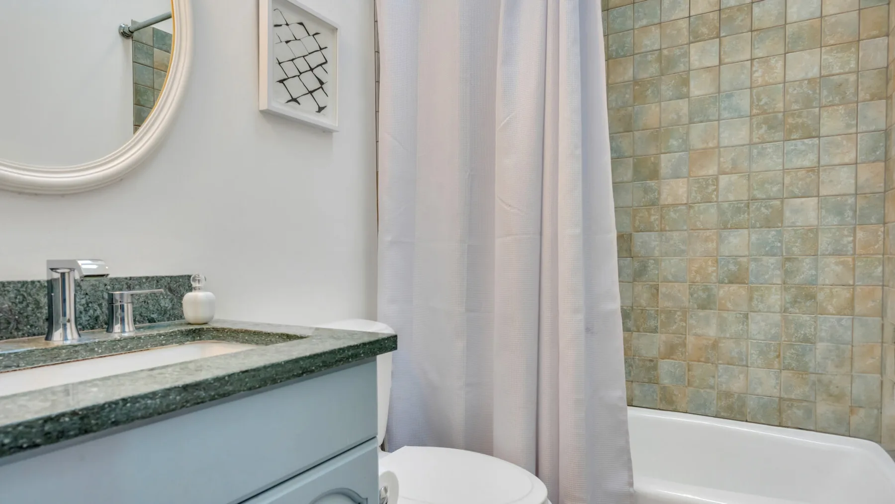 Un lavabo de baño está junto a una ducha con cortina.