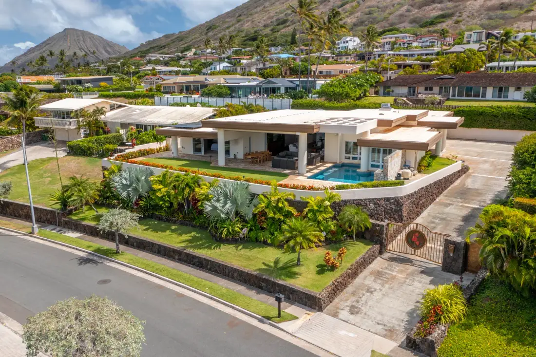 Una casa moderna con piscina se encuentra entre jardines.