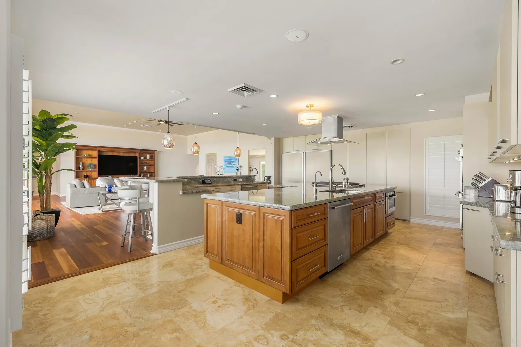 Una cocina abierta con una isla de madera y una sala contigua.