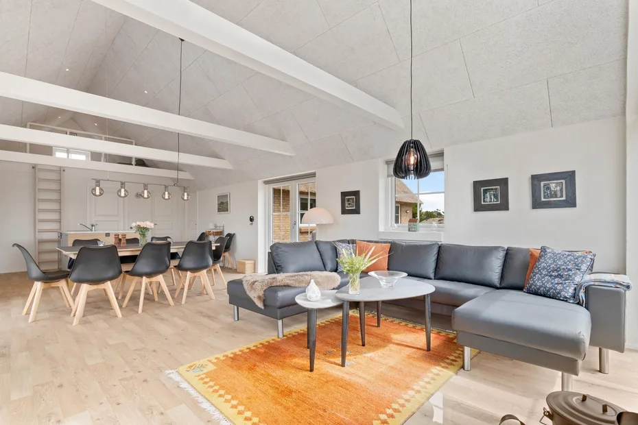 Sala de estar y comedor de concepto abierto con asientos seccionales y una mesa de comedor.