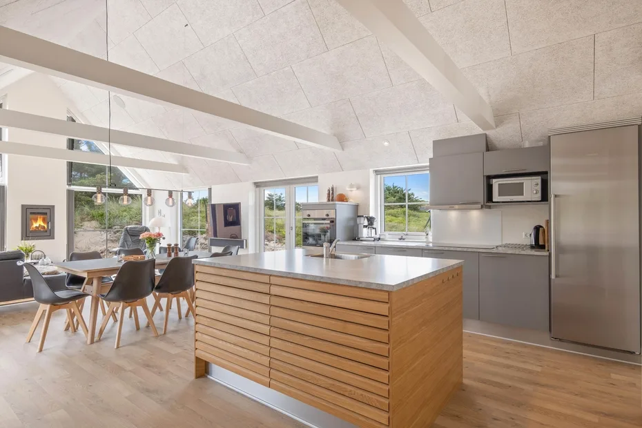 Cocina y comedor de planta abierta con una gran isla central y una mesa de comedor.